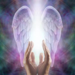 A pair of hands with angel wings providing spiritual healing in front of a colorful background.